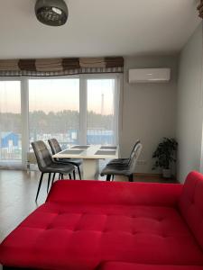 Una sala de estar con un sofá rojo y sillas. en Holiday Home, en Druskininkai