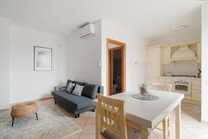 a kitchen and living room with a table and a couch at Spacious Apartment 600 mt to Metro M3 Comasina in Milan