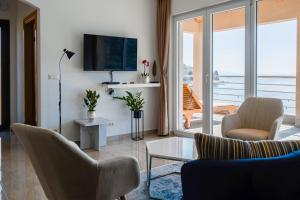 a living room with a couch and chairs and a television at Nika Seafront - Rabac, Istria in Rabac