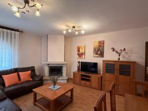 Una sala de estar con un sofá y un televisor. en El Prau la Iglesia Porrua - Llanes, en Porrúa
