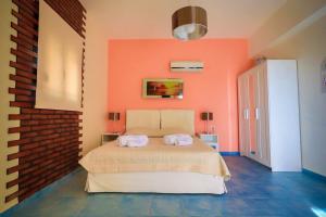 a bedroom with a bed with an orange wall at Villa Amor in Pefki Rhodes