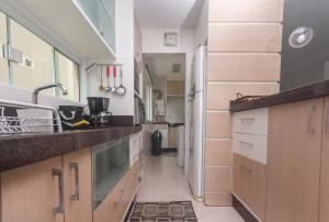 a kitchen with a sink and a refrigerator at Apartamento Almeida e Moraes 3 Suítes com Hidro in Itapema