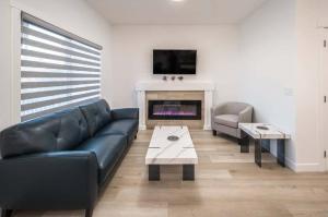 a living room with a couch and a fireplace at Stay Together! 2 Family Units, Sleeps 16! FREE Banff Pass, Parking, Wine, BBQ, & Netflix! in Calgary