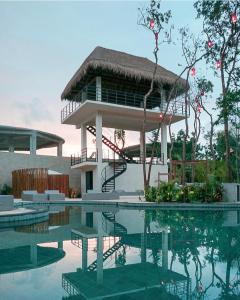 um resort com piscina e um prédio em Adora Tulum em Tulum