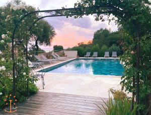 a swimming pool with lounge chairs and an archway at Ogliastrello in Olmeto