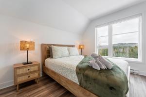 a white bedroom with a bed and a window at Le Raffine hot tub River Front in Saint Come