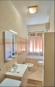 a bathroom with a sink and a toilet and a mirror at Holidayhouse in Civitavecchia