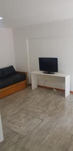 a room with a bed and a desk with a tv at CaSa VALENTINA in San Clemente del Tuyú