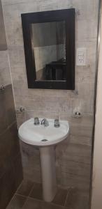 a bathroom with a white sink and a mirror at CaSa VALENTINA in San Clemente del Tuyú