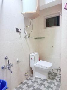 a bathroom with a white toilet and a sink at Cv Lodge in Srinagar