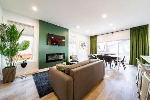 a living room with a couch and a dining room at 5BR-Luxury Retreat-Hot Tub-King Bed-Rogers Place-DT in Edmonton