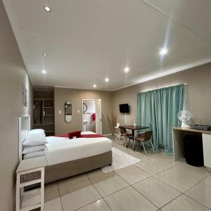 a large bedroom with a bed and a table at Hidden Bliss Guesthouse in East London