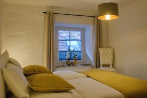 a bedroom with a bed with yellow pillows and a window at Ferienwohnung Silvia in Villingen-Schwenningen