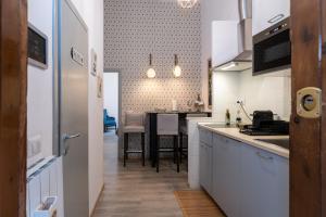 a kitchen with white cabinets and a dining room at A Casa Lamperini 59 in Rome +6 photos