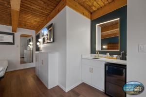 a kitchen with white cabinets and a wooden ceiling at The Eastpoint Suite #1 in Lake Geneva