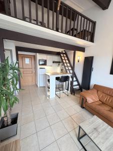 a living room with a loft bed and a kitchen at les reflets in Saint-Cyprien-Plage