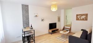 a living room with a couch and a tv at Cœur d'émeraude in Moissac