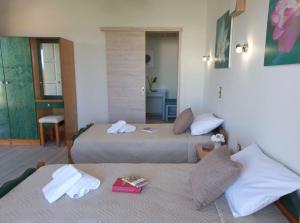 a hotel room with two beds and a table at Amazing Swimming Pool Stamatia-Maria Apt in Kavros +29 photos
