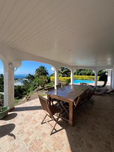 a wooden table on a patio with a view of the ocean at Te Tai Marama in Uturoa