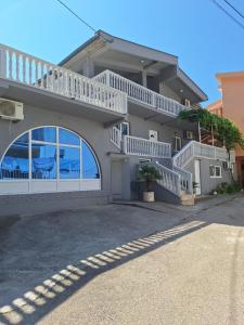 a house with white balconies and a driveway at Marko Apartment in Sutomore