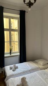 two beds in a bedroom with a window at Kamienica Śródmieście Apartament 18A in Warsaw