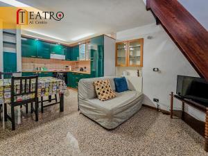 a living room with a chair and a table and a kitchen at Teatro al Centro in Ancona