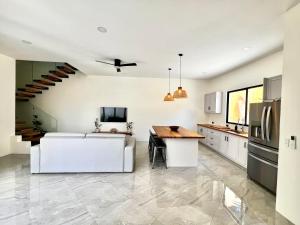a kitchen with a dining table and a kitchen with a staircase at Casa María - Playa hermosa Cóbano in Playa hermosa