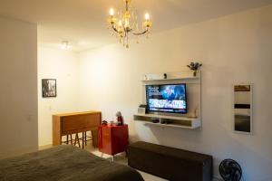 a bedroom with a tv on the wall at Apartamento Le Quatre Avenida in Monte Verde