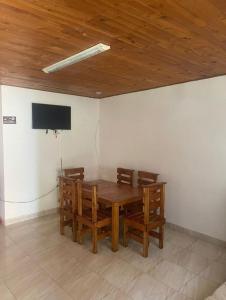 a room with a wooden table and a tv on the wall at Los micos in San Rafael