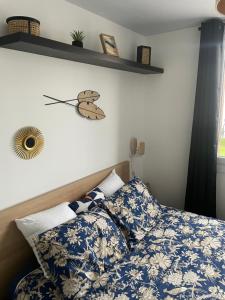 a bedroom with a bed with a butterfly clock on the wall at Bel appartement spacieux ,convivial de 3 chambres avec parking privé sécure in Caen