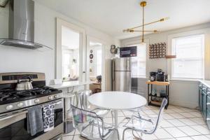 a kitchen with a table and a stove and a sink at Revamped 3BR Apt with Easy Check-In Family-Friendly in Bridgeport