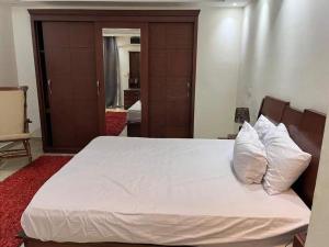 a bedroom with a bed with white sheets and pillows at الجفر موتل in Al Jafr