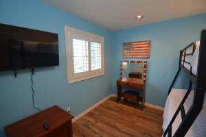 a bedroom with a bed and a desk with a mirror at Bearadise At North Shore Free Night Special in Bass Lake