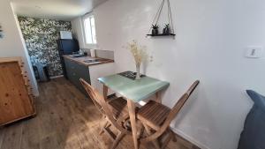 a table and chairs in a room with a kitchen at La Petite Maison in Saint-Rémy-lès-Chevreuse