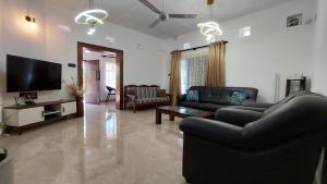 a living room with two couches and a flat screen tv at Majestic Villa in Galle