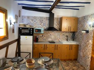 a kitchen with a table and a refrigerator and a sink at La casa palo in Cehegín