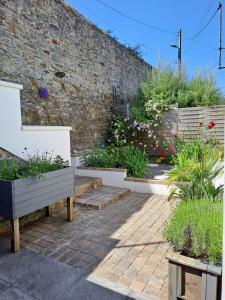 a garden with a brick wall and some plants at Charmante maison dans le centre historique de Morlaix in Morlaix +4 photos