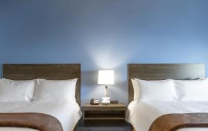 two beds in a hotel room with a blue light at My Place Hotel-Huntersville, NC in Huntersville