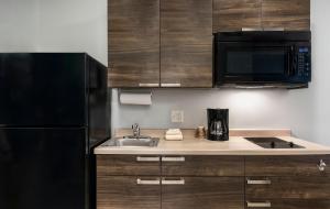 a kitchen with a sink and a black refrigerator at My Place Hotel-Huntersville, NC in Huntersville +14 photos