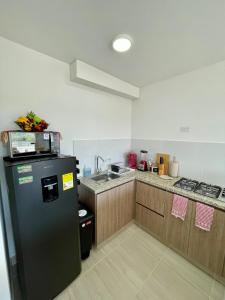 Charming apartment in Cartagena في Puerto Tierrabaja: مطبخ مع ثلاجة سوداء ومغسلة