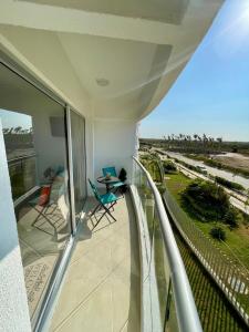 Charming apartment in Cartagena في Puerto Tierrabaja: شرفة مطلة على الشاطئ وأشجار النخيل