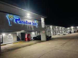 a parking lot in front of a parakeet inn at night at Paradise Inn-Montebello,Los Angeles in Montebello