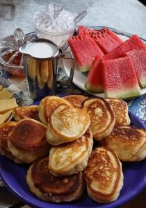 a blue plate with pancakes and watermelon on a table at Alpes San Rafael in San Rafael