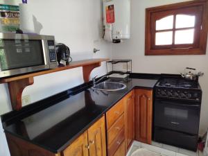 a kitchen with a sink and a microwave at Fede Tridente in Pinamar