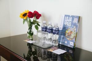 a table with bottles of water and a vase with flowers at Hotel San Sebastián Loja in Loja