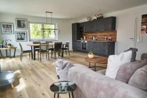 a living room and kitchen with a couch and a table at Ferienwohnungen Auf der alten Gärtnerei GmbH in Günzburg