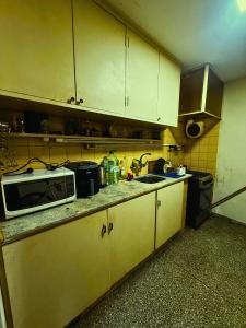 a small kitchen with a microwave and a sink at Habitación en apartamento en Parque Battle Montevideo in Montevideo
