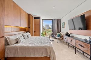 a bedroom with a large bed and a flat screen tv at Zantamar - Beachfront Suites in La Cruz in Cruz de Huanacaxtle