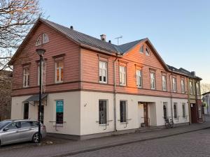 a wooden building with a car parked in front of it at Linnuse Apartement in Haapsalu