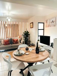 Una sala de estar con una mesa de madera y sillas blancas. en Dani House - Porto Moniz Escape, en Porto Moniz